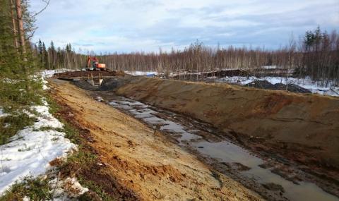 Lietteenkuivausallas. Lietteen laskeuduttua vesi lasketaan pois altasta taustalla näkyvän padon avulla