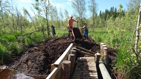 Otto Moilanen ja Matti Kaskentola korjaavat Saarisenoja padon pään syöpymää